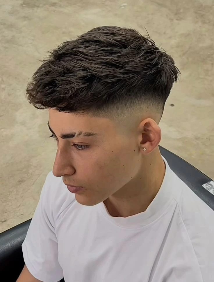 Corte de pelo corto con textura y degradado bajo, perfecto para volumen y estilo en la parte superior.