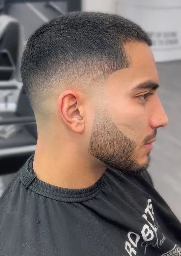 Corte de pelo tipo buzz con degradado bajo, fácil de mantener y de estilo minimalista.