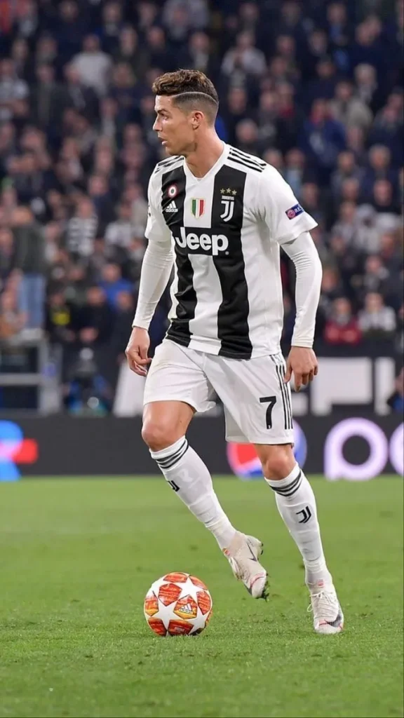 Cristiano Ronaldo jugando al fútbol, luciendo su característico corte de pelo moderno y elegante, demostrando su habilidad y estilo en el campo.
