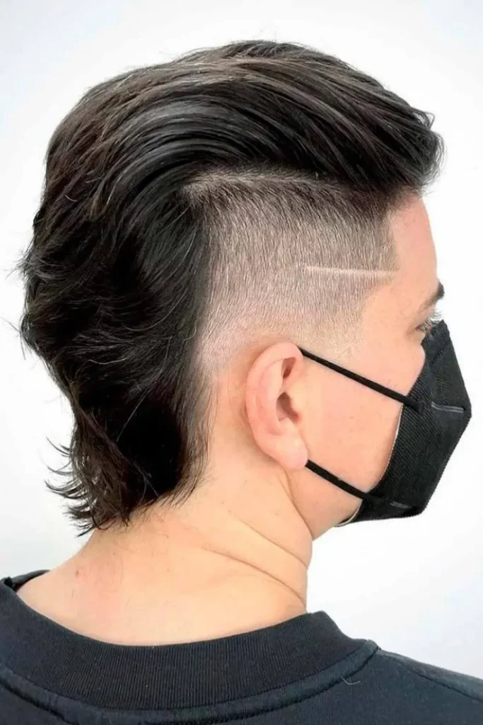 Corte de pelo mullet con undercut, con los lados rapados y la parte posterior más larga, ofreciendo un estilo moderno y audaz.