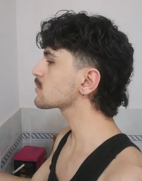 Corte de pelo mullet corto clásico, con los lados rapados y el cabello largo en la parte posterior para un estilo sofisticado y atemporal.