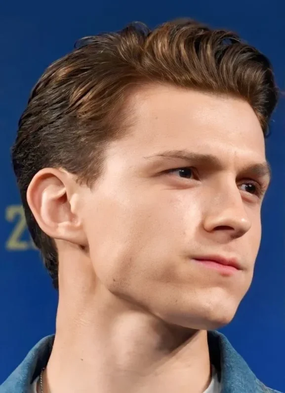 Corte de pelo corto clásico al estilo Tom Holland, con los lados cortos y la parte superior peinada hacia atrás para un look elegante y formal.