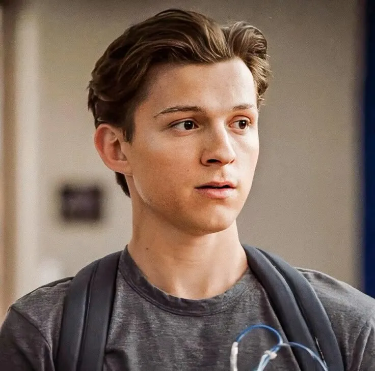 Corte de pelo con tupé texturizado al estilo Tom Holland, con volumen en la parte superior y lados degradados para un look sofisticado.